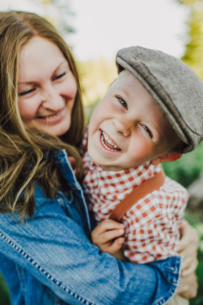 Mom and toddler boy smiling and hugging.