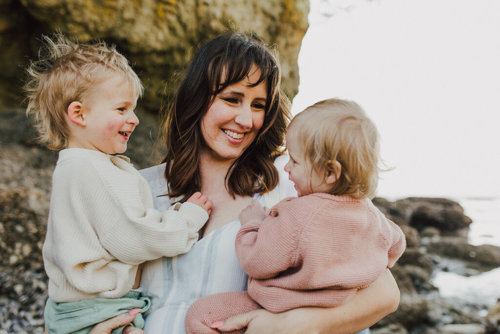 A mother holding her two toddler children