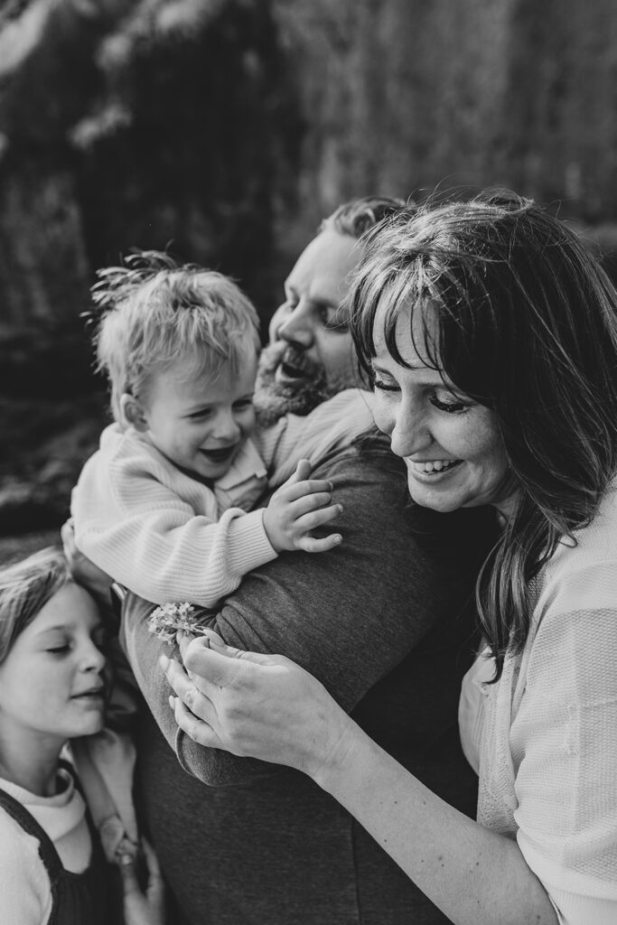 A mom, dad and two children. The younger child just gave his mother a flower