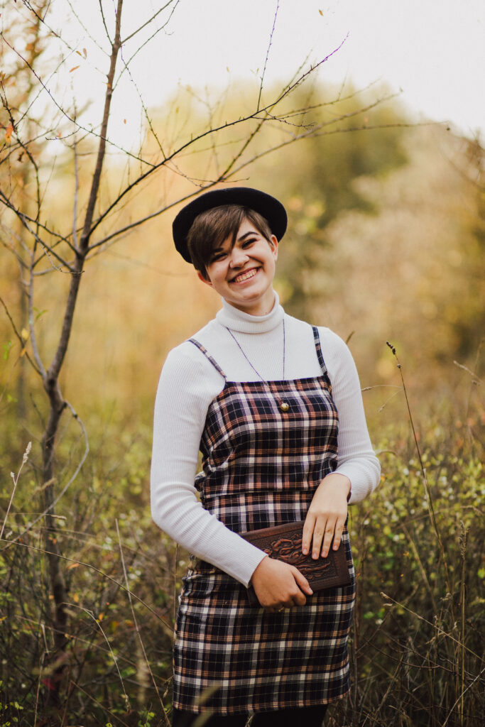 An artistic looking girl wearing a beret holding her sketchbook