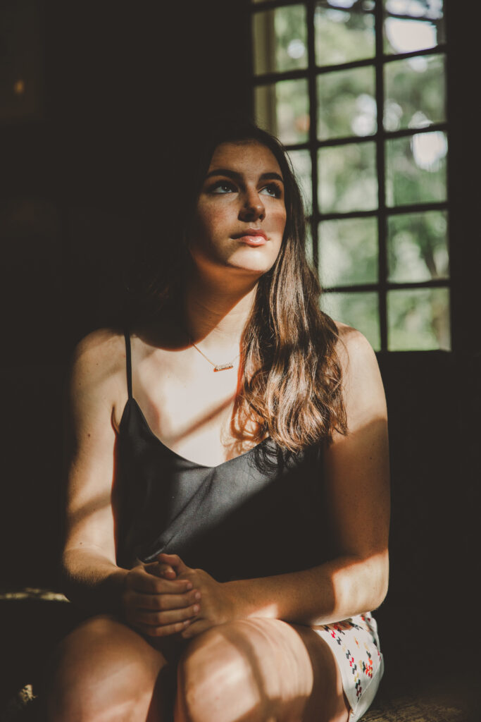 A girl sitting and looking out the window.