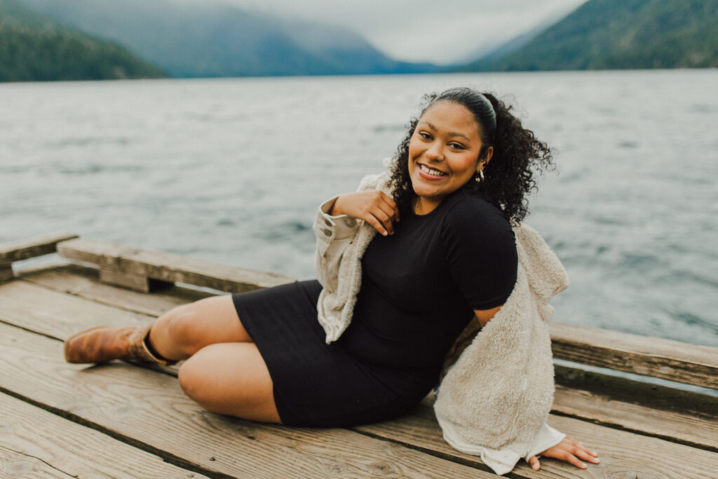 Girl sitting on the dock with Lake Crescent in the background