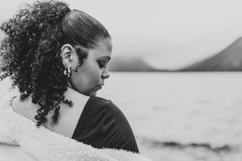 Black and white image of a high school senior looking out at Lake Crescent 