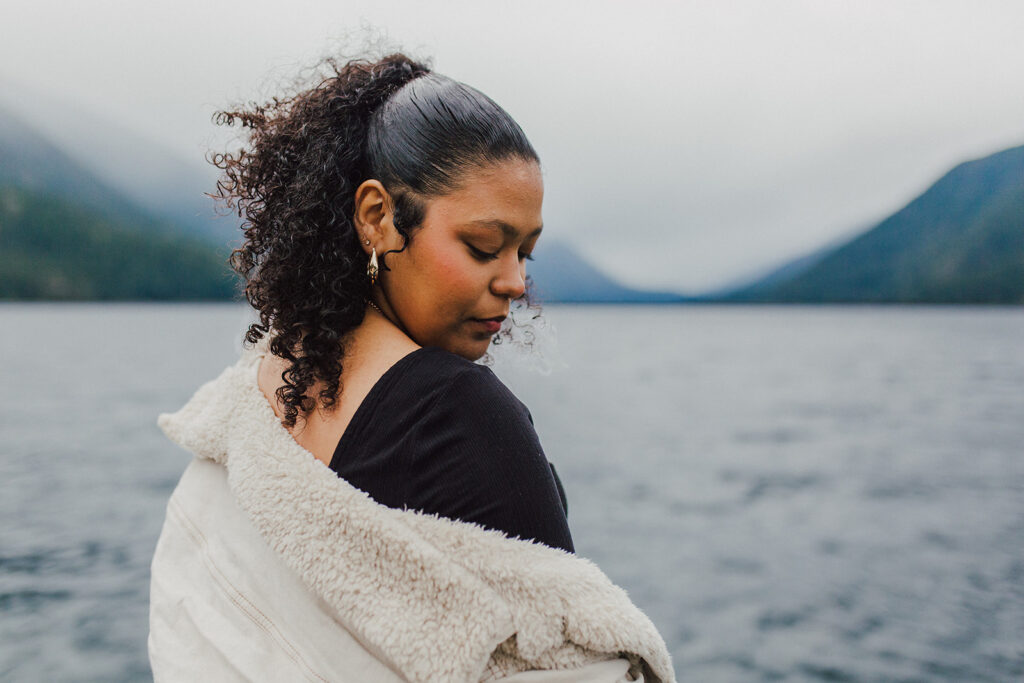 Girl looking down pensively with Lake Crescent in the background